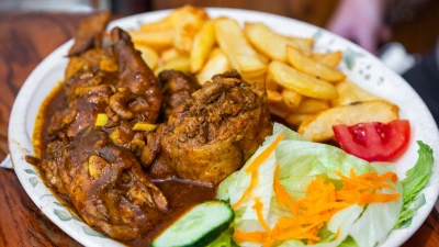 Maltese rabbit stew served with chips and salad
