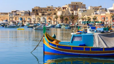 Colourful luzzu fishing boats moored in Marsaxlokk harbour