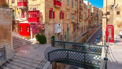 Valletta street with a red phone box, shutters and balconies