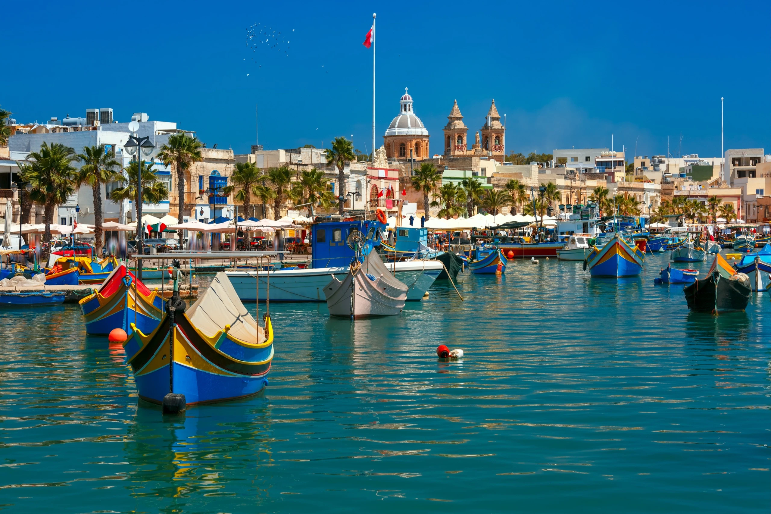 Colourful luzzu fishing boats with painted eyes in Marsaxlokk harbour