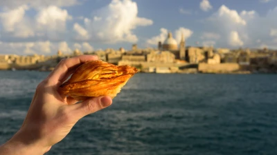 Pastizzi, Maltese ricotta pastries, with Valletta in the background