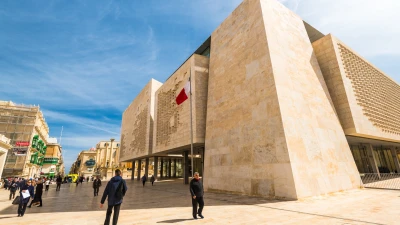 People walking past Malta's Parliament building in Valletta