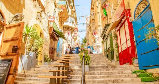 Sunny street with colourful balconies in Valletta
